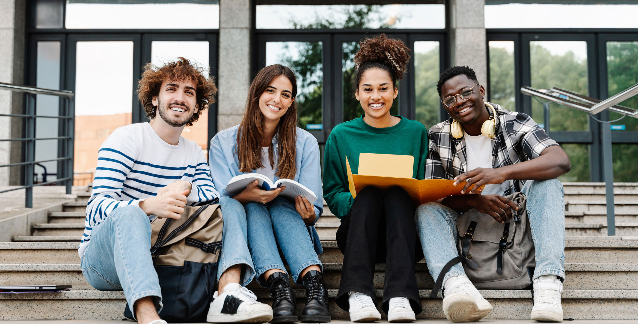 college studets sitting on stairs at main entrance